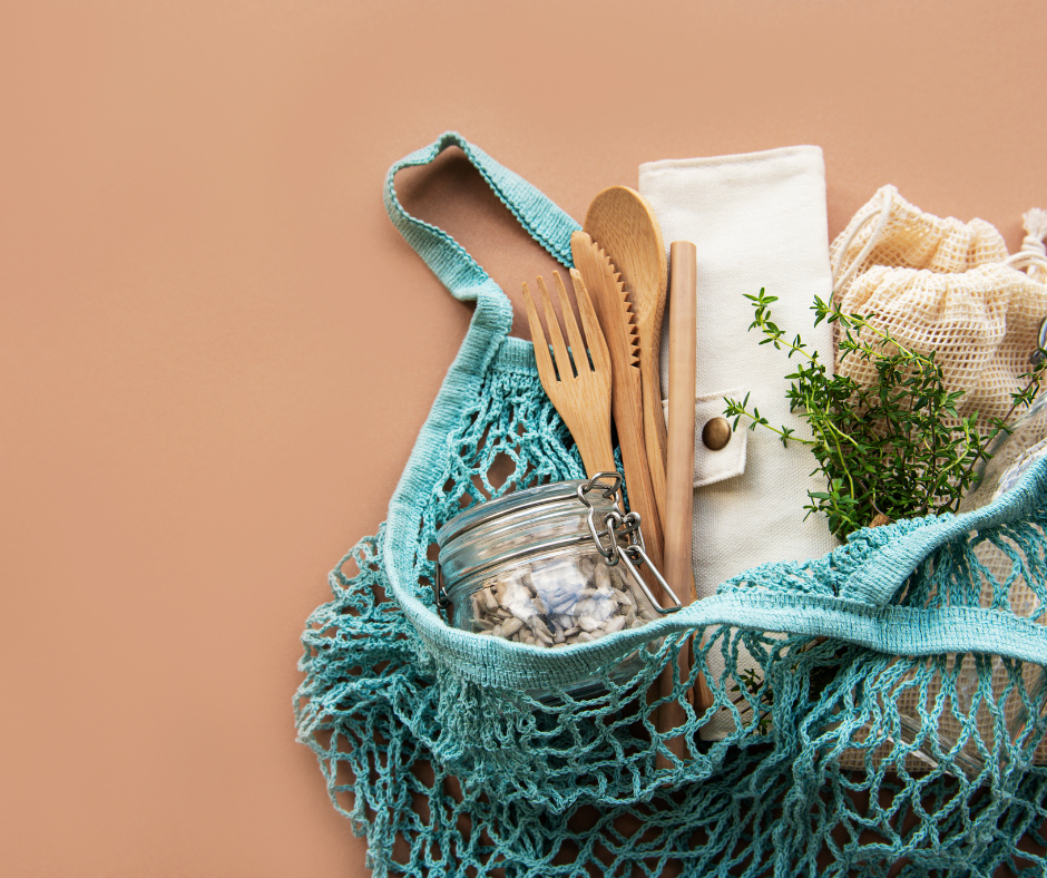 Image of a blue string bag filled with a glass jar, wooden cutlery and other items Image of a blue string bag filled with a glass jar, wooden cutlery and other items