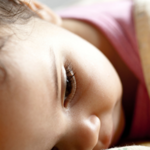 Child daydreaming Child laying down and thinking with an up close focused image on her eye.