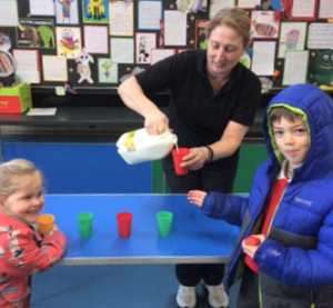 Georgeham without single use plastic milk cartons! Keri Lambert, school dinner assistant at Georgeham Primary School pouring milk for pupils at Devon's first Plastic Free School