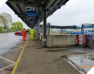 HWRC Picture of Pinbrook Household waste recycling centre with 2 staff walking along a pathway beside the recycling skips