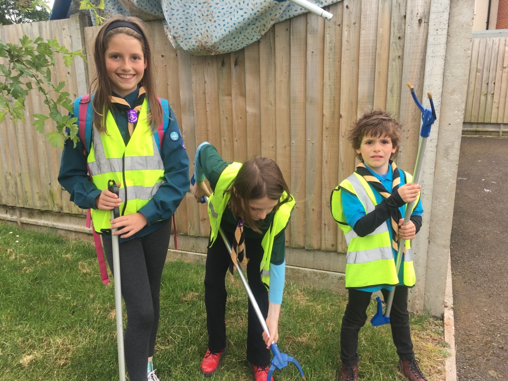 Youth Groups 3 children in Scout, Cub and Beaver uniforms with litter pickers