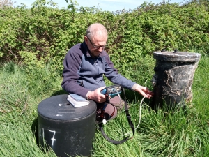 An Inspector using monitoring equipment to measure gas from a redundant landfill site