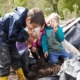 Children using magnifying glasses to study compost in an outdoor environment