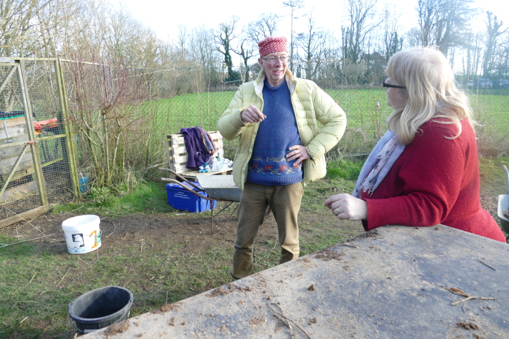 Dr Compost, Nicky Scott, talking to Mrs Williams about composting in school Two people talking while one leans on a composting bin