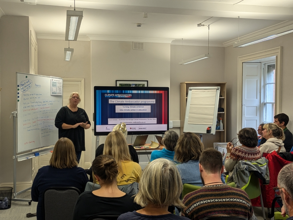 A lady presenting the climate ambassador programme to a group of people.