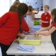 Children using trays of newspaper and water to make new paper