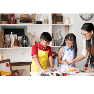 Two children with an adult doing arts and crafts