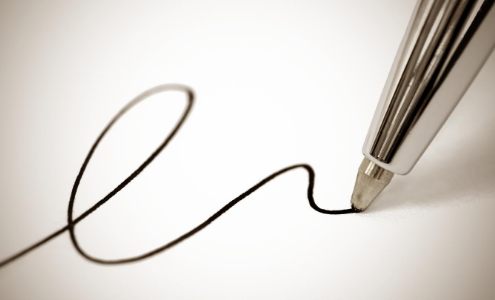 Untitled design(4) Close up image of a ballpoint pen nib signing a piece of paper
