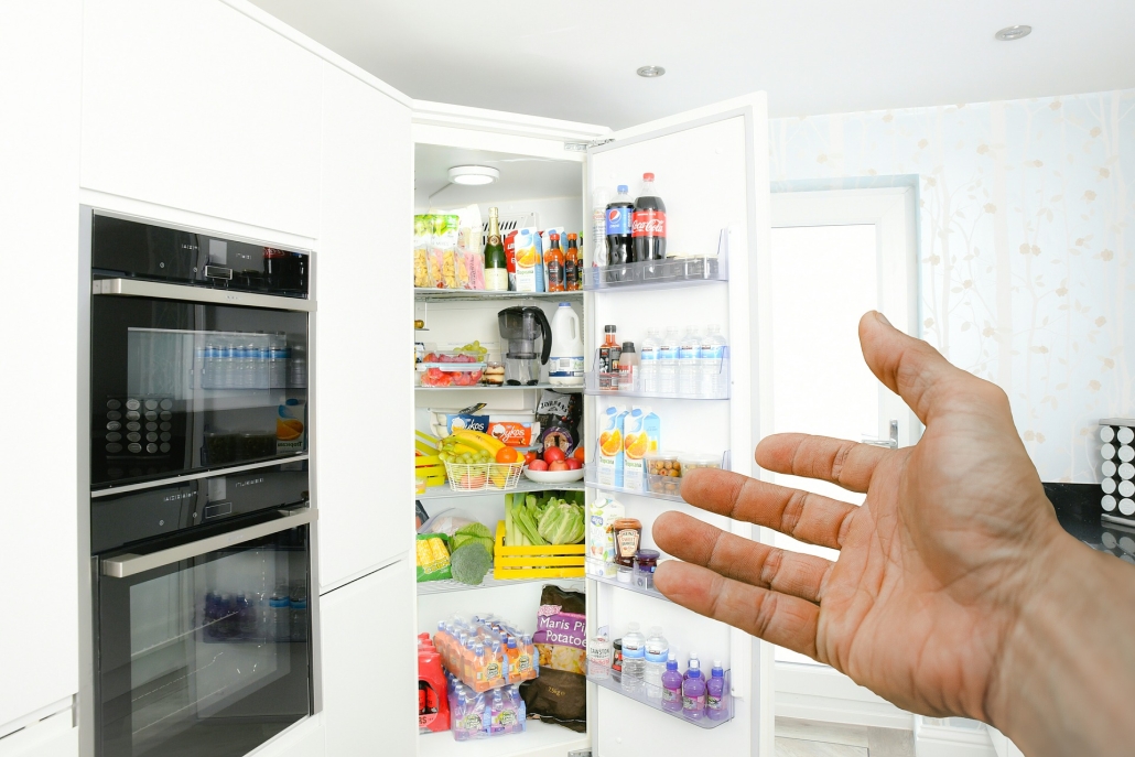 Fridge Image of an open white fridge full of fruit and vegetables and drinks in a kitchen