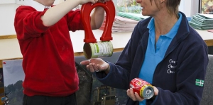 materials-workshop-metals Child and waste educator Sally with magnet separating steel can from aluminium can