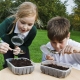 2 children looking for minibeasts in the compost
