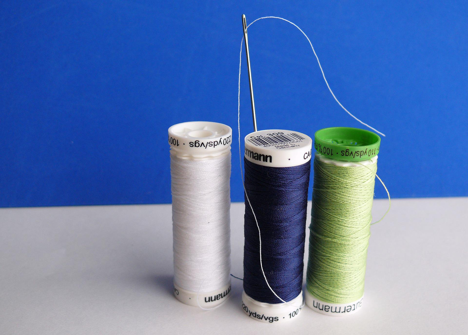 Needle and thread 3 spools of cotton thread in navy blue, green and white with a sewing needle