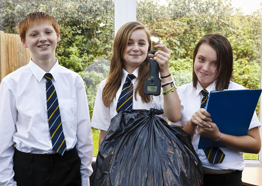 waste-audit-ks2 Smiling secondary students with bag of rubbish, scales and clipboard